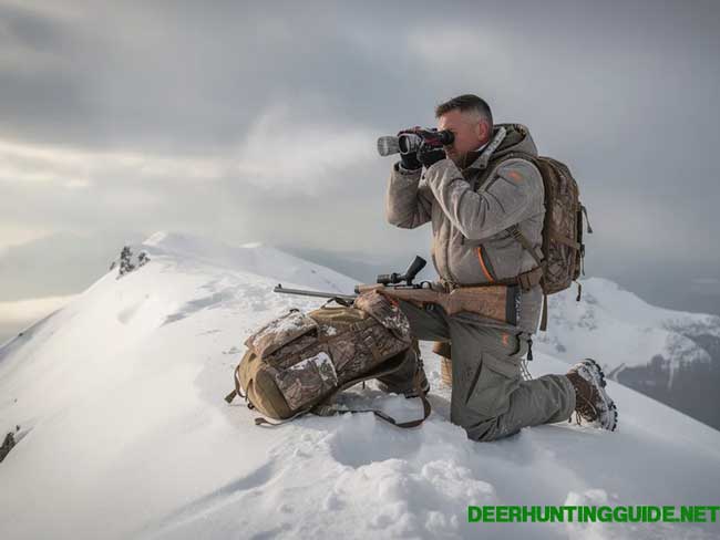 A hunter is glassing from a snowy ridge, dressed in insulated hunting pants designed for cold weather. The camo pattern of the pants blends with the winter landscape, showcasing the functionality and warmth of his hunting gear. A hunter is glassing from a snowy ridge, dressed in insulated hunting pants designed for cold weather. The camo pattern of the pants blends with the winter landscape, showcasing the functionality and warmth of his hunting gear.