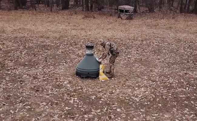 Hunter Filling The Capsule Automatic Deer Feeder Hunter Filling The Capsule Automatic Deer Feeder