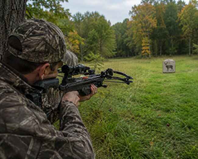 Hunter Shooting A Crossbow Bolt At A Target Hunter Shooting A Crossbow Bolt At A Target